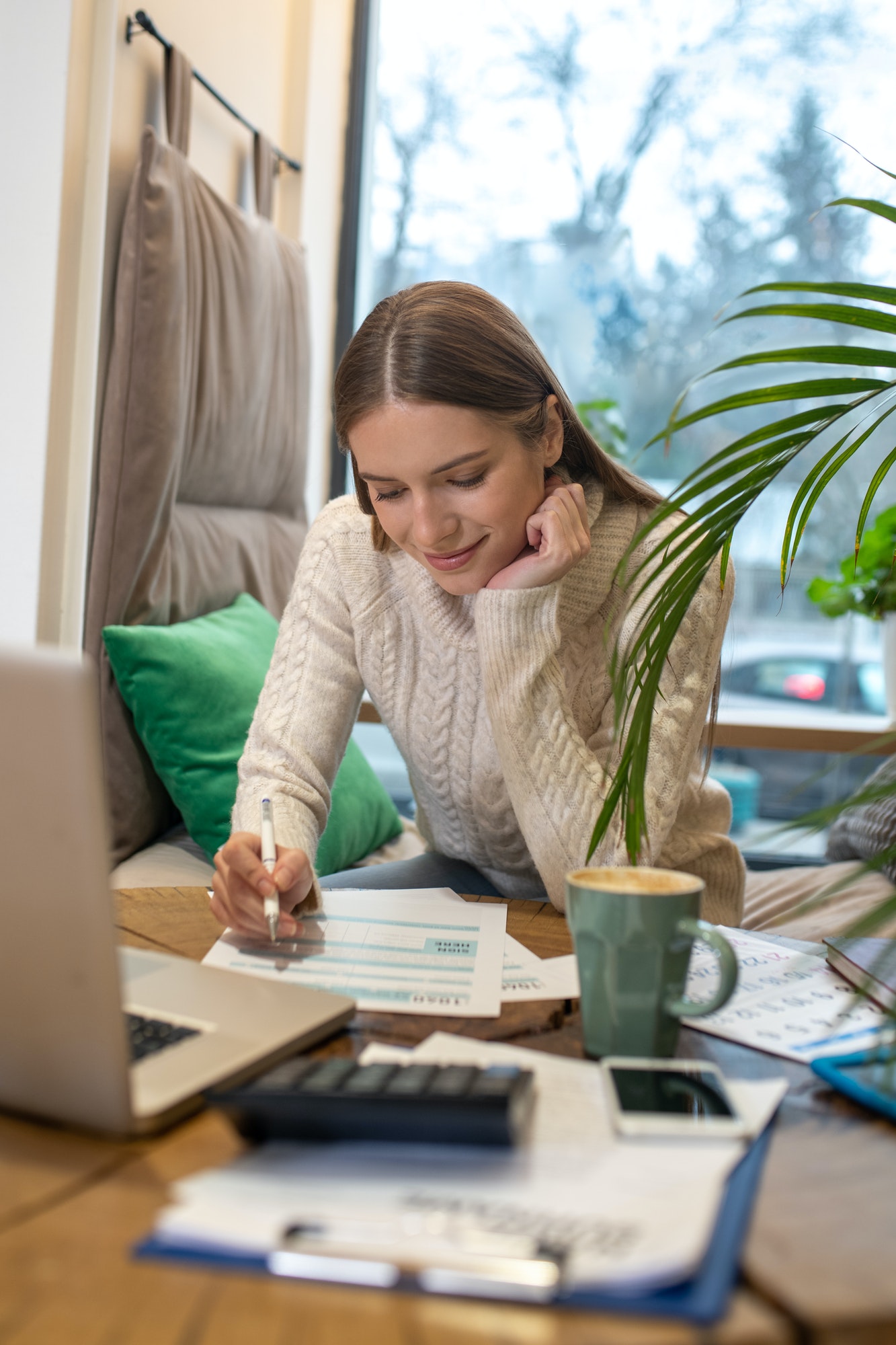 Concentrated woman calculating taxes and expenses for her business